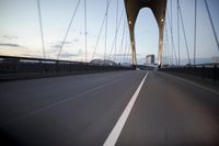 a car going over a bridge at sunset with city skyline in the background as seen from a moving vehicle