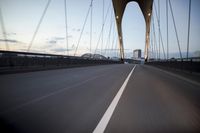 a car going over a bridge at sunset with city skyline in the background as seen from a moving vehicle