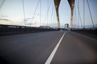 a car going over a bridge at sunset with city skyline in the background as seen from a moving vehicle