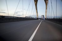 a car going over a bridge at sunset with city skyline in the background as seen from a moving vehicle