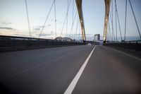 a car going over a bridge at sunset with city skyline in the background as seen from a moving vehicle
