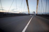 a car going over a bridge at sunset with city skyline in the background as seen from a moving vehicle