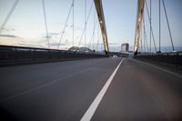 a car going over a bridge at sunset with city skyline in the background as seen from a moving vehicle