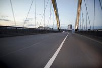a car going over a bridge at sunset with city skyline in the background as seen from a moving vehicle