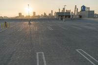 an empty parking lot overlooking the city skyline at sunset time with an airplane taking off