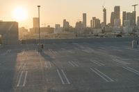 an empty parking lot overlooking the city skyline at sunset time with an airplane taking off