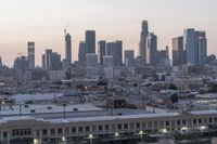 a view of the city with buildings in it at sunset and overcast skies behind