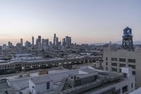 a view of the city with buildings in it at sunset and overcast skies behind