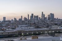 a view of the city with buildings in it at sunset and overcast skies behind