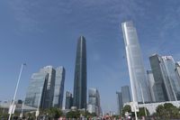 a city skyline with many tall buildings and people walking on a walkway along it, with a person in a stroller and one man walking away