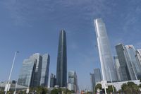 a city skyline with many tall buildings and people walking on a walkway along it, with a person in a stroller and one man walking away