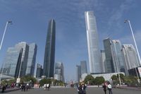 a city skyline with many tall buildings and people walking on a walkway along it, with a person in a stroller and one man walking away