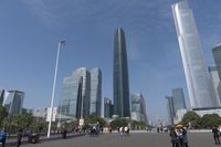 a city skyline with many tall buildings and people walking on a walkway along it, with a person in a stroller and one man walking away