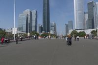 a city skyline with many tall buildings and people walking on a walkway along it, with a person in a stroller and one man walking away