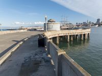 view of the city skyline from a pier with a large water tank in the foreground