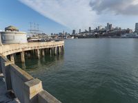 view of the city skyline from a pier with a large water tank in the foreground