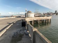 view of the city skyline from a pier with a large water tank in the foreground