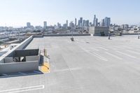 a view of a parking lot overlooking a city skyline, and a red and yellow fire hydrant