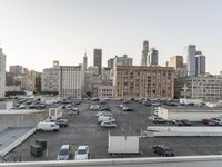 the view of buildings and street from a rooftop parking lot, near a cityscape