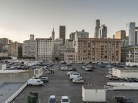 the view of buildings and street from a rooftop parking lot, near a cityscape