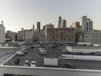 the view of buildings and street from a rooftop parking lot, near a cityscape