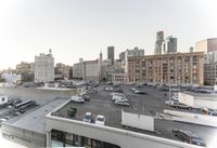 the view of buildings and street from a rooftop parking lot, near a cityscape