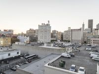 the view of buildings and street from a rooftop parking lot, near a cityscape