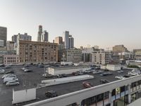 the view of buildings and street from a rooftop parking lot, near a cityscape