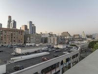 the view of buildings and street from a rooftop parking lot, near a cityscape