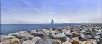 a view of the skyline across the water on rocks by the coast area of an island