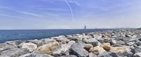 a view of the skyline across the water on rocks by the coast area of an island