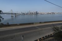 a view of the water and city skyline across a wide bay, with a bridge on both sides