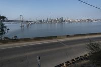 a view of the water and city skyline across a wide bay, with a bridge on both sides