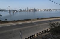 a view of the water and city skyline across a wide bay, with a bridge on both sides