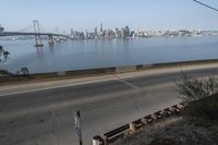 a view of the water and city skyline across a wide bay, with a bridge on both sides