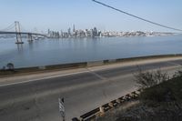 a view of the water and city skyline across a wide bay, with a bridge on both sides