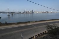 a view of the water and city skyline across a wide bay, with a bridge on both sides