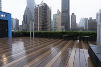 wooden decking area with benches and city skyline view with skyscrapers in the distance