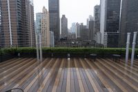 wooden decking area with benches and city skyline view with skyscrapers in the distance