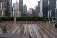 wooden decking area with benches and city skyline view with skyscrapers in the distance