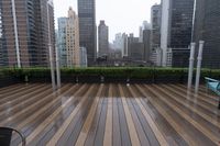 wooden decking area with benches and city skyline view with skyscrapers in the distance