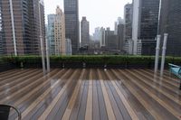 wooden decking area with benches and city skyline view with skyscrapers in the distance