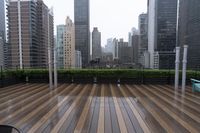 wooden decking area with benches and city skyline view with skyscrapers in the distance