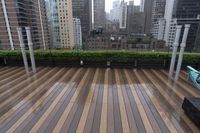 wooden decking area with benches and city skyline view with skyscrapers in the distance