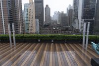 wooden decking area with benches and city skyline view with skyscrapers in the distance