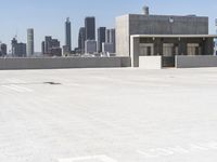 a yellow fire hydrant sitting in a parking lot next to a city skyline with tall buildings