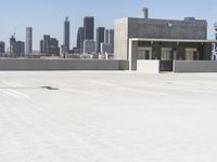 a yellow fire hydrant sitting in a parking lot next to a city skyline with tall buildings