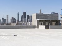 a yellow fire hydrant sitting in a parking lot next to a city skyline with tall buildings