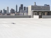 a yellow fire hydrant sitting in a parking lot next to a city skyline with tall buildings