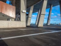 an empty parking lot has concrete pillars and walls that connect with each other in the background